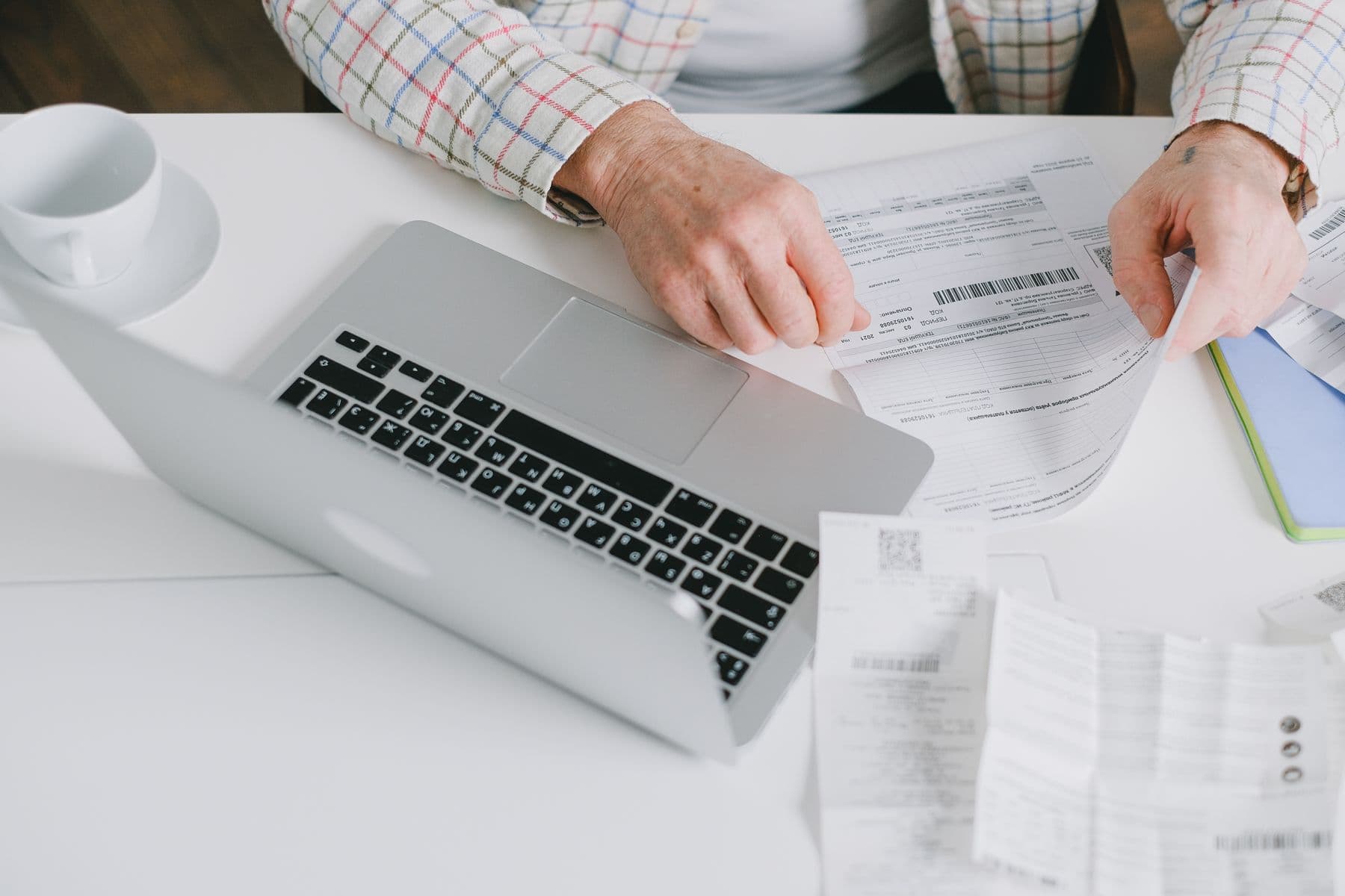 Documentos e notebook em uma rotina de controle financeiro